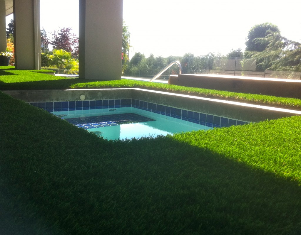 Synthetic grass around hot tub helps eliminate dirt and gravel in the water.